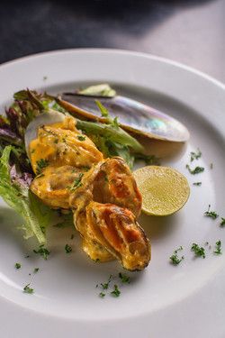 Pan fried mussels with creamy paprika sauce served on a bed of lettuce 